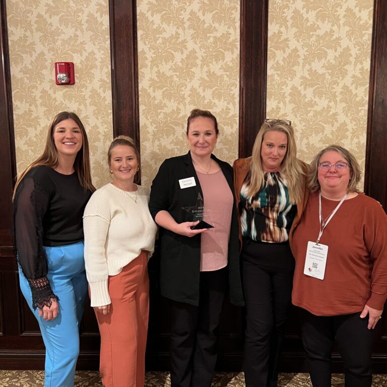 North Shore Team standing with award